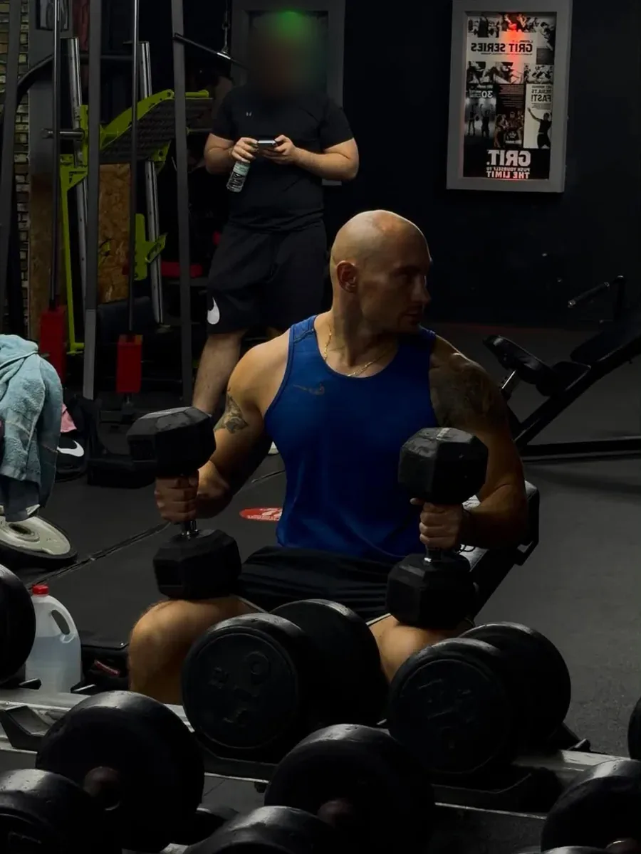 Nikita seated with dumbbells
